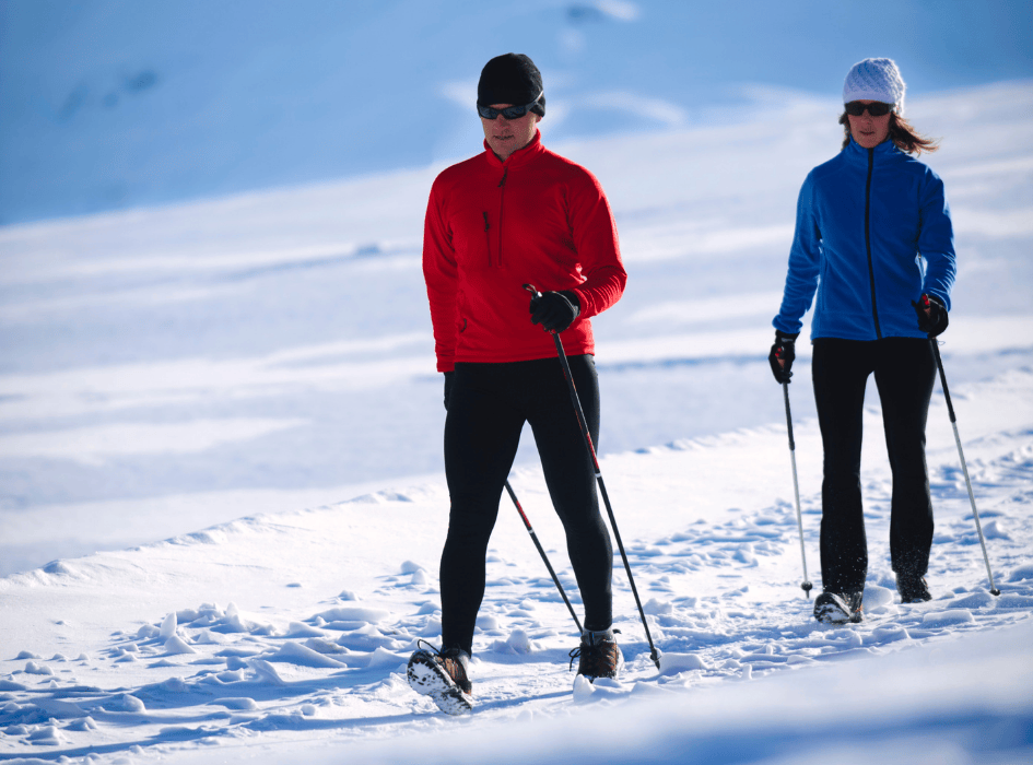Muž a žena s nordic walking palicami na snehu-alt