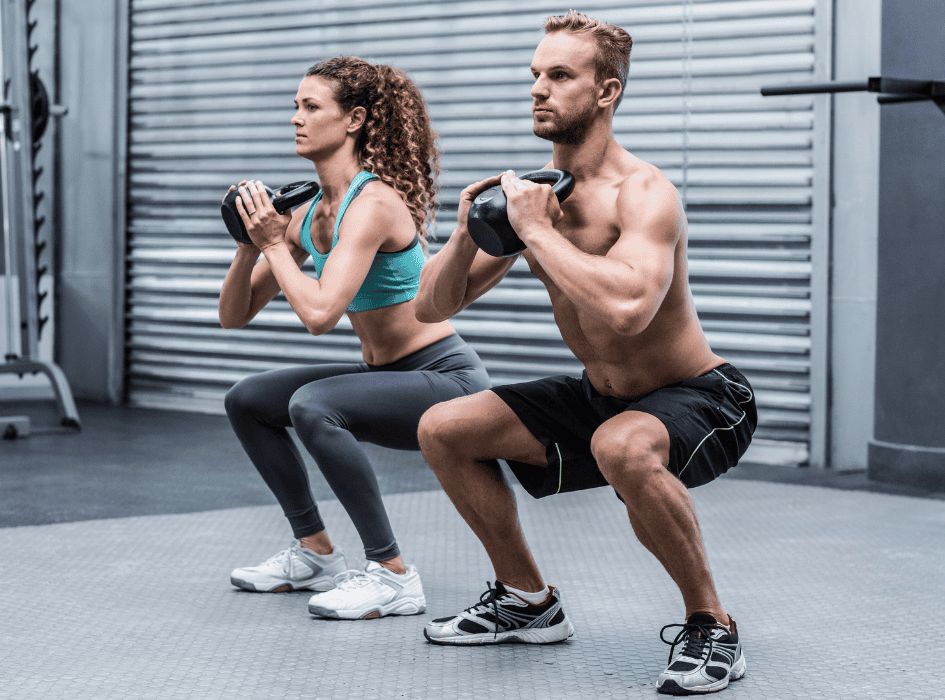 Muž a žena v gymu dřepují s kettlebell-cz-alt