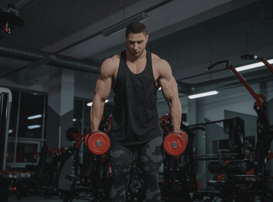 Muž ve fitku zvedá červené činky-cz-alt