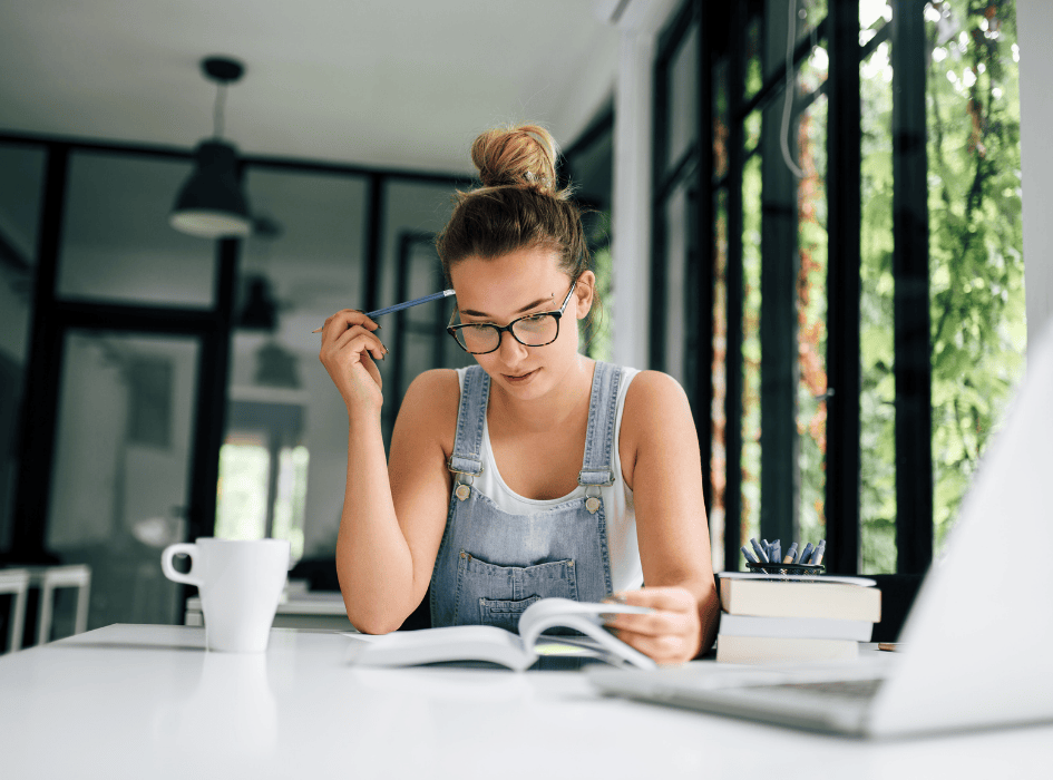 dievča sa učí s kopou kníh a šálkou kávy-alt