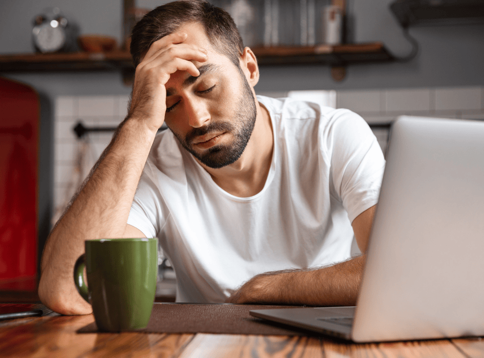Mężczyzna odpoczywa zmęczony od komputera i opiera głowę na
