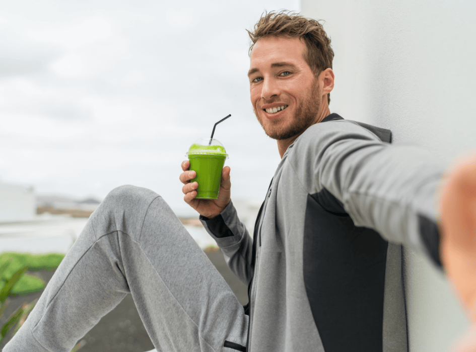 Muž v teplákovce pije zelený nápoj Daily BOOST-cz-alt