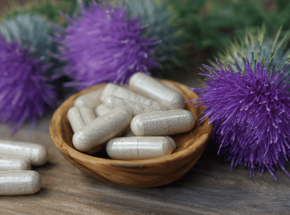 pestrec mariánsky rastlina a výživový doplnok z pestreca mariánskeho v kapsulách uložený v drevenej miske