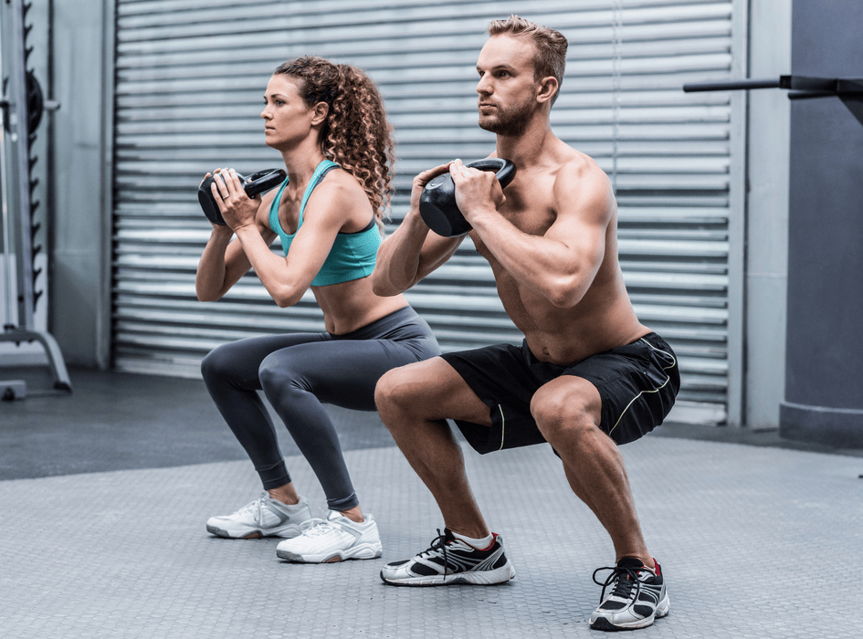 Muž a žena cvičí dřep s kettlebellem, mobilita a stabilita kloubů při silovém tréninku