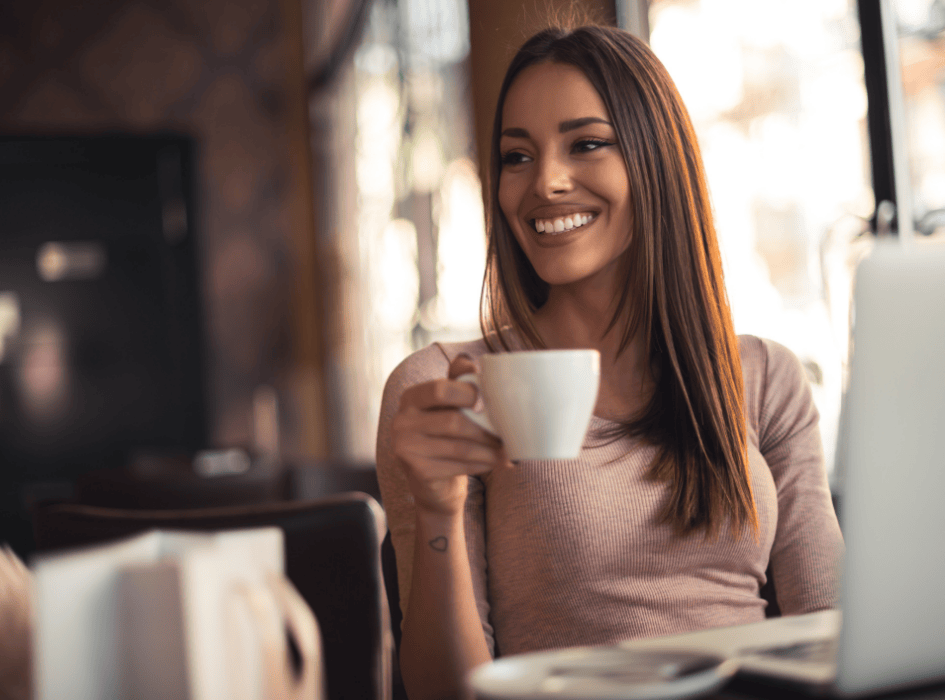 usměvavá žena u počítače pije kávu-cz-alt