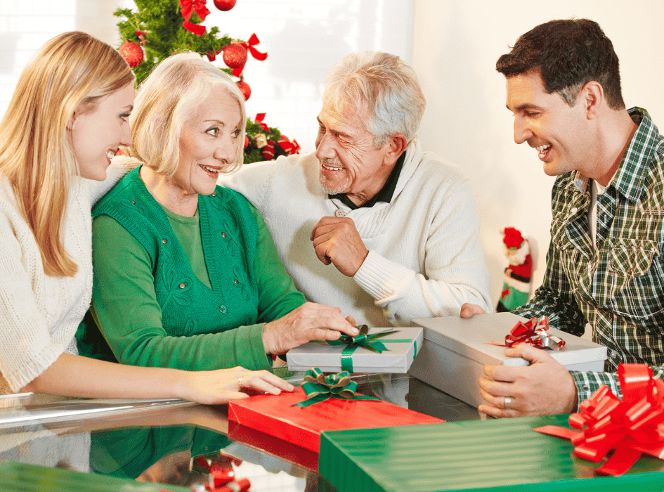 žena a muž dávajú na vianoce darček starým rodičom-alt