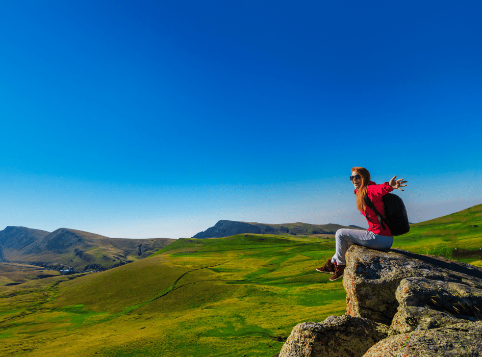 žena na vrchole hory turistka
