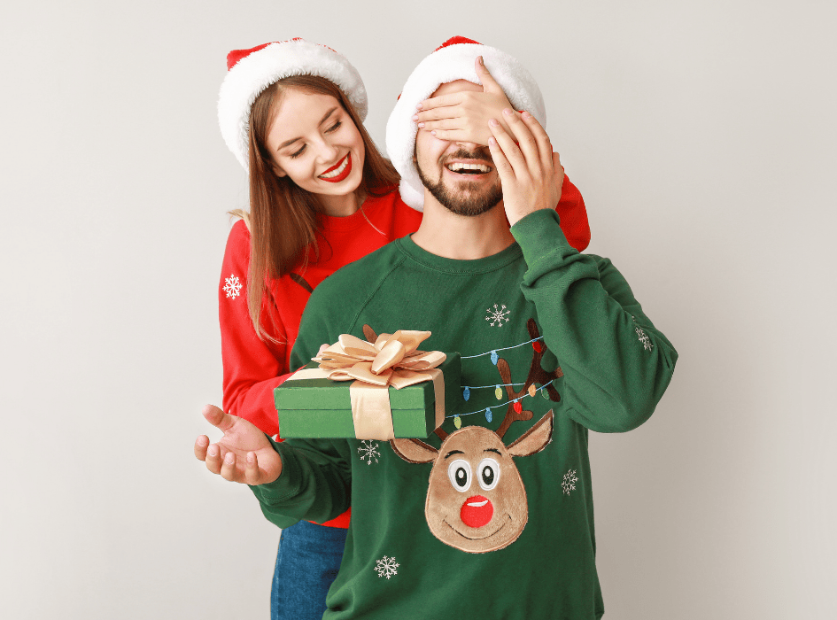 žena obdarovává muže sportovce na vánoce, drží mu oči-cz-alt